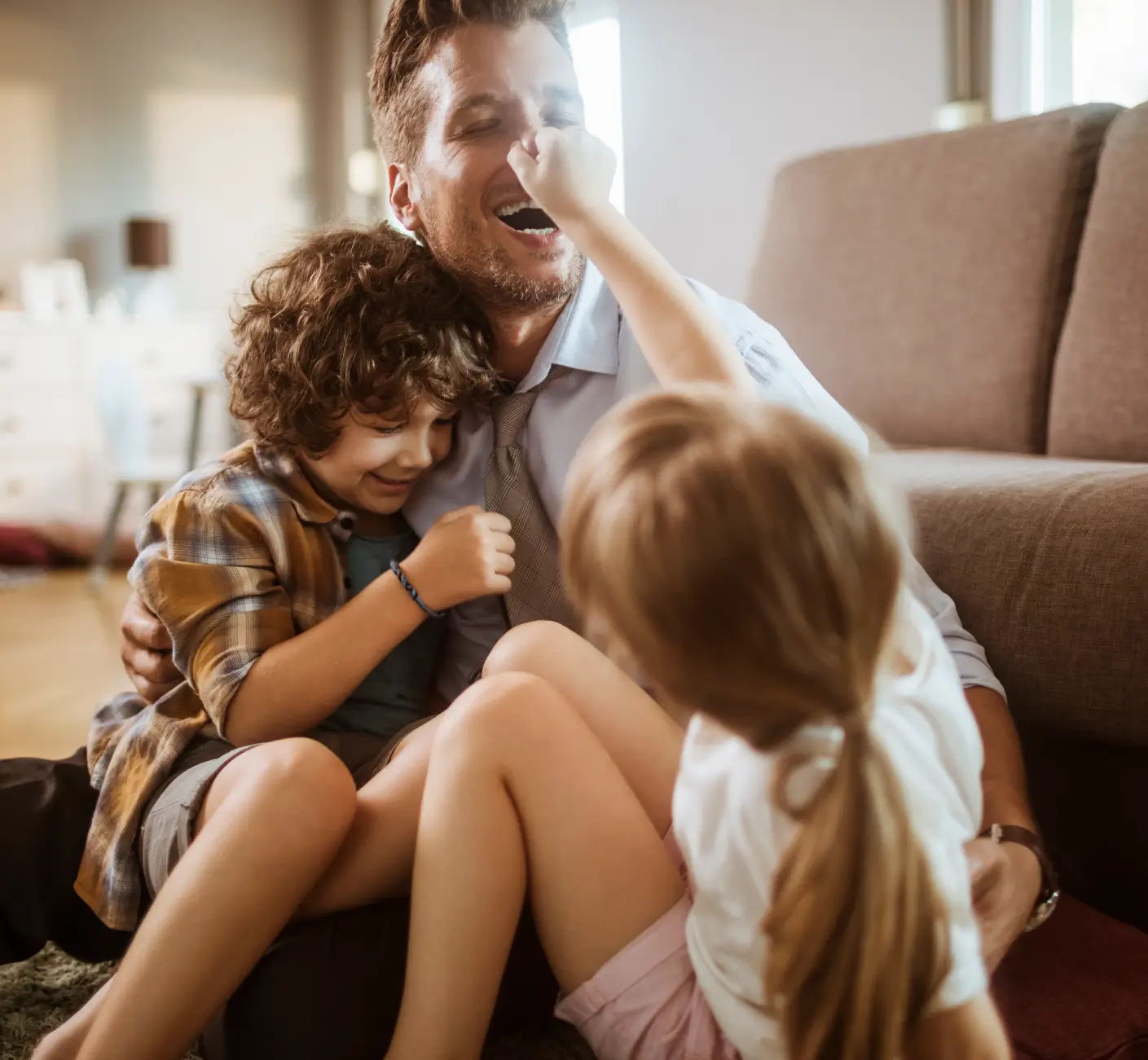 Två familjehemsplacerade barn som leker med mannen i sin nya familj