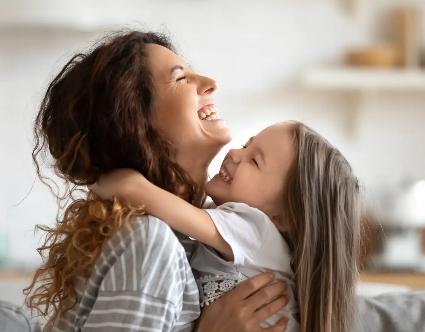 En medelålders kvinna som kramar en flicka på 4 år